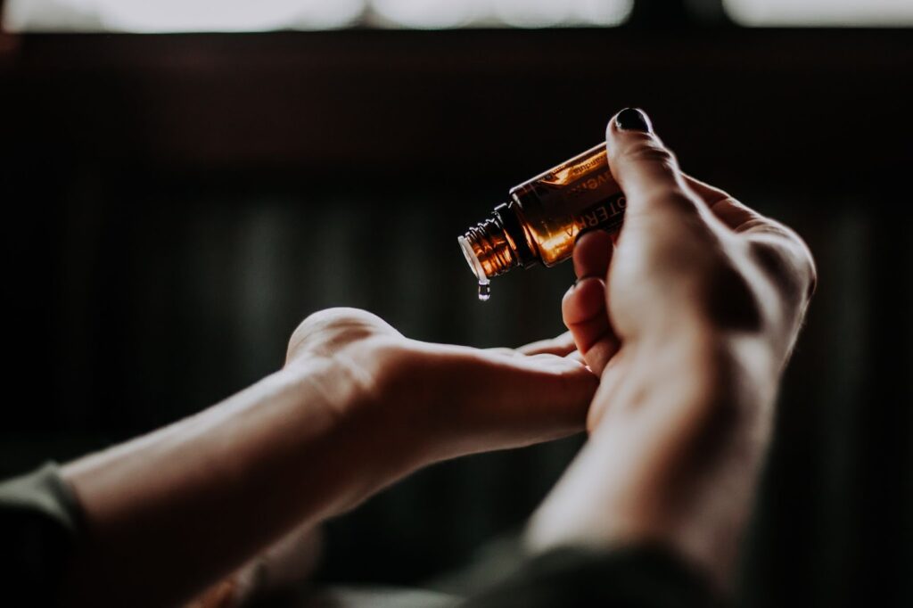 CBD oil drop falling on the palm of a hand