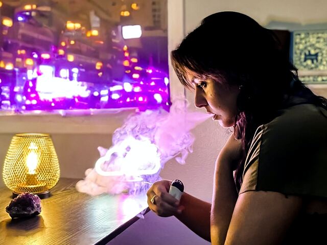 person vapes by the window