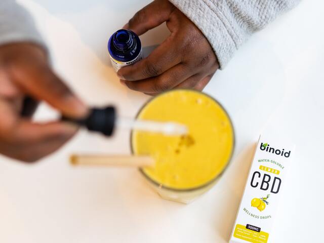 person drops cbd oil for pain in the juice