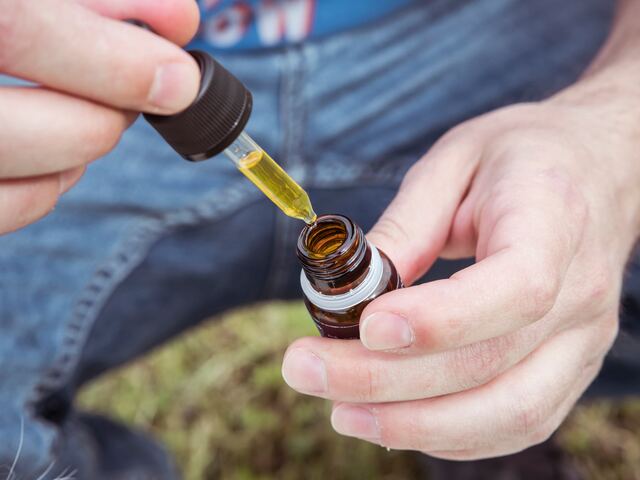 hands holding cbd oil bottle