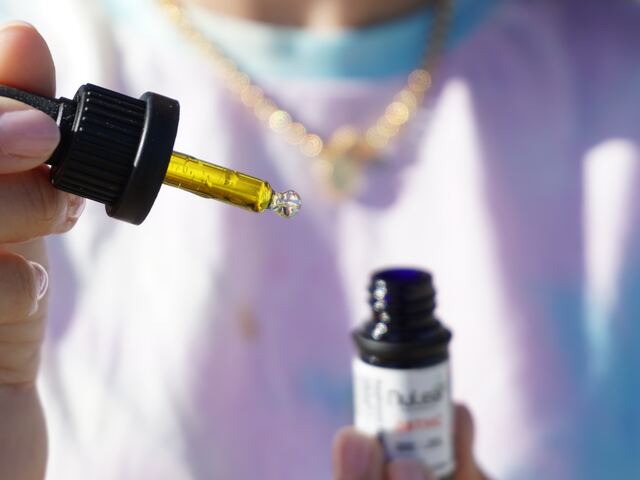 person holds e liquid bottle