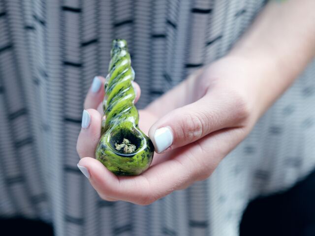 person holding glass pipe with small cbd dose