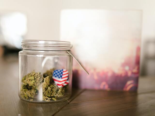 small jar of cbd flowers with paper american flag